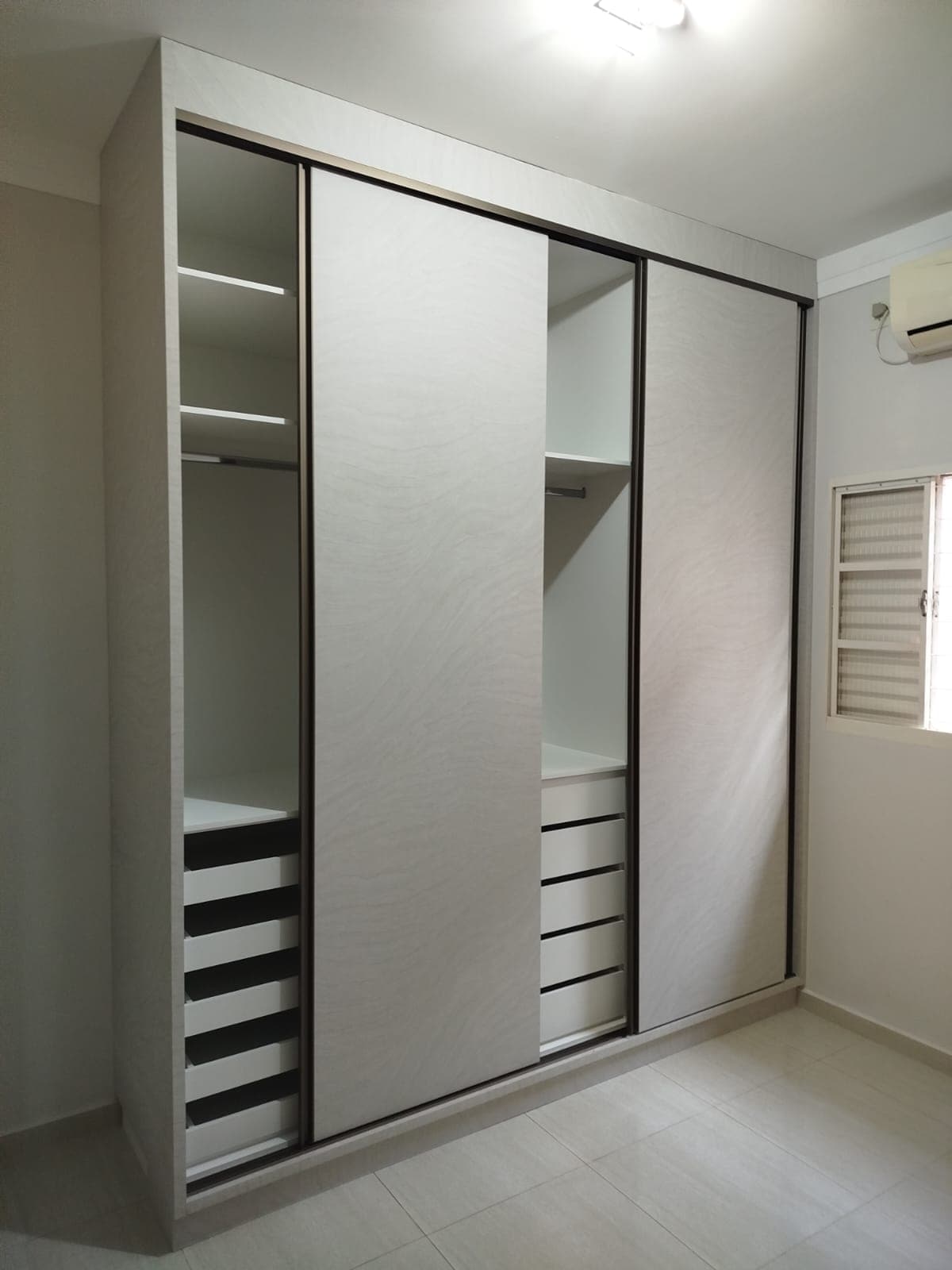 Interior de guarda-roupa organizado com gavetas e cabideiro