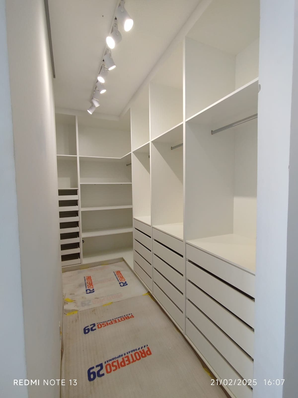 Closet planejado branco com iluminação embutida