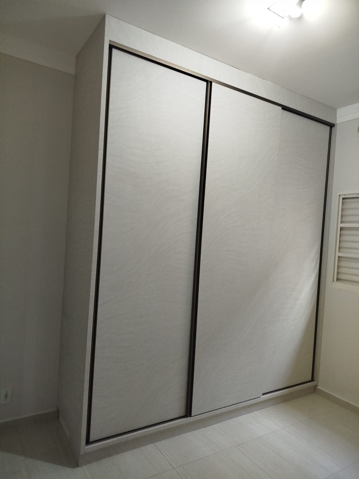 Closet em tom café com espelho e gaveteiro