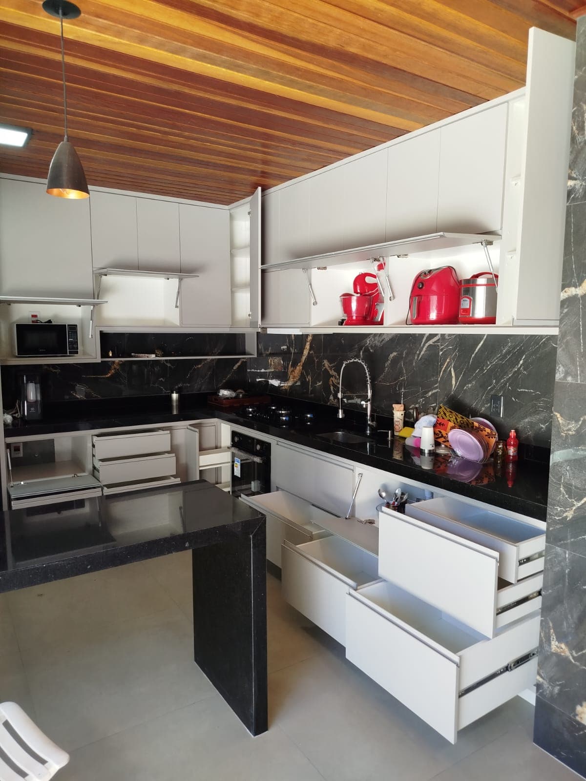 Cozinha branca com revestimento em mármore preto e dourado